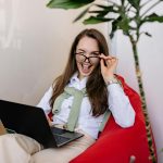 winking woman with a laptop on her lap